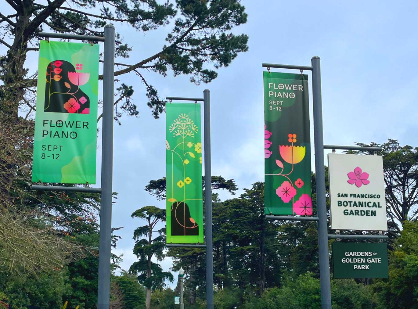 Banner in the San Francisco Botanical Garden “Gardens of Golden Gate Park” with the text “Flower Piano Sept 8 - 12” with trees in the background